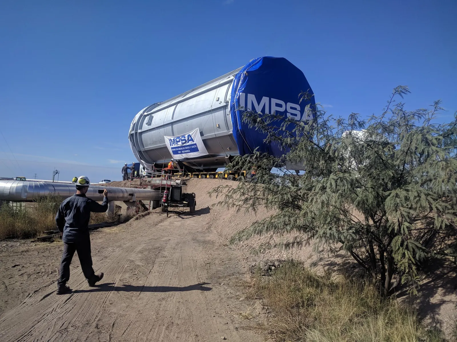 Una persona camina hacia un equipo industrial en traslado